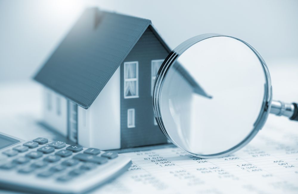 家の模型と虫メガネ