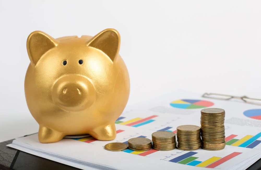 金のぶたの貯金箱とコインとグラフの画像